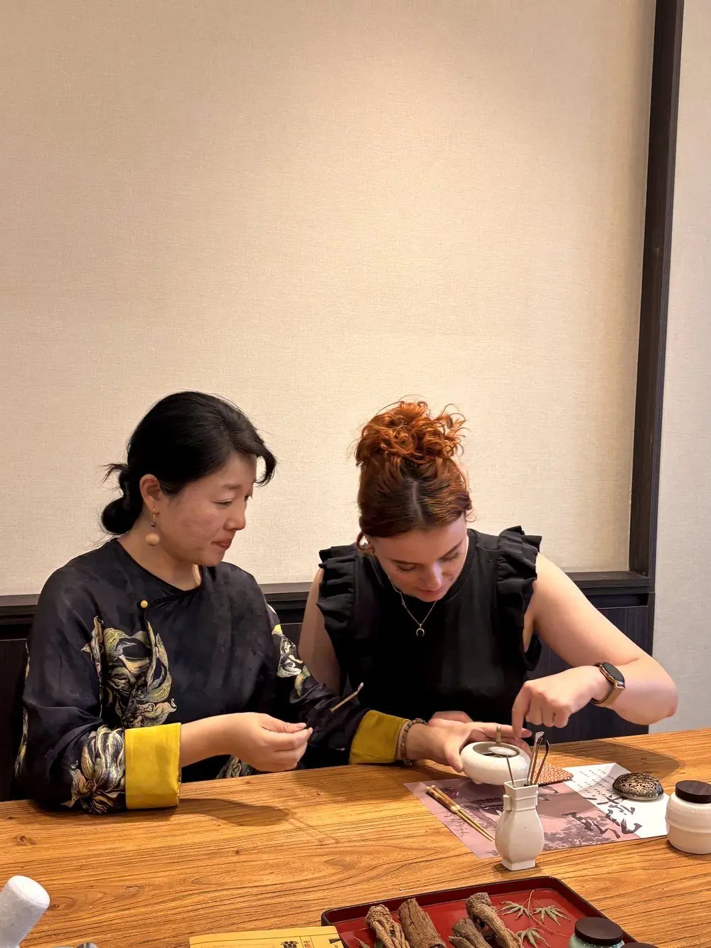 A guest and host working together during a hands-on cultural wellness session